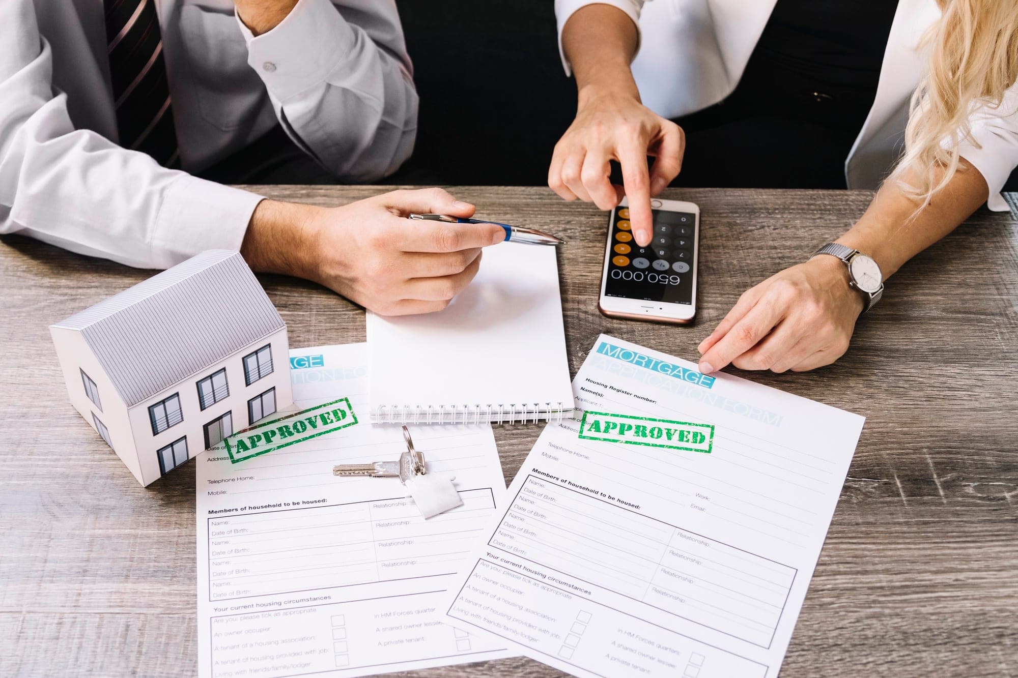 Business people discuss GST implications on selling commercial property with documents.