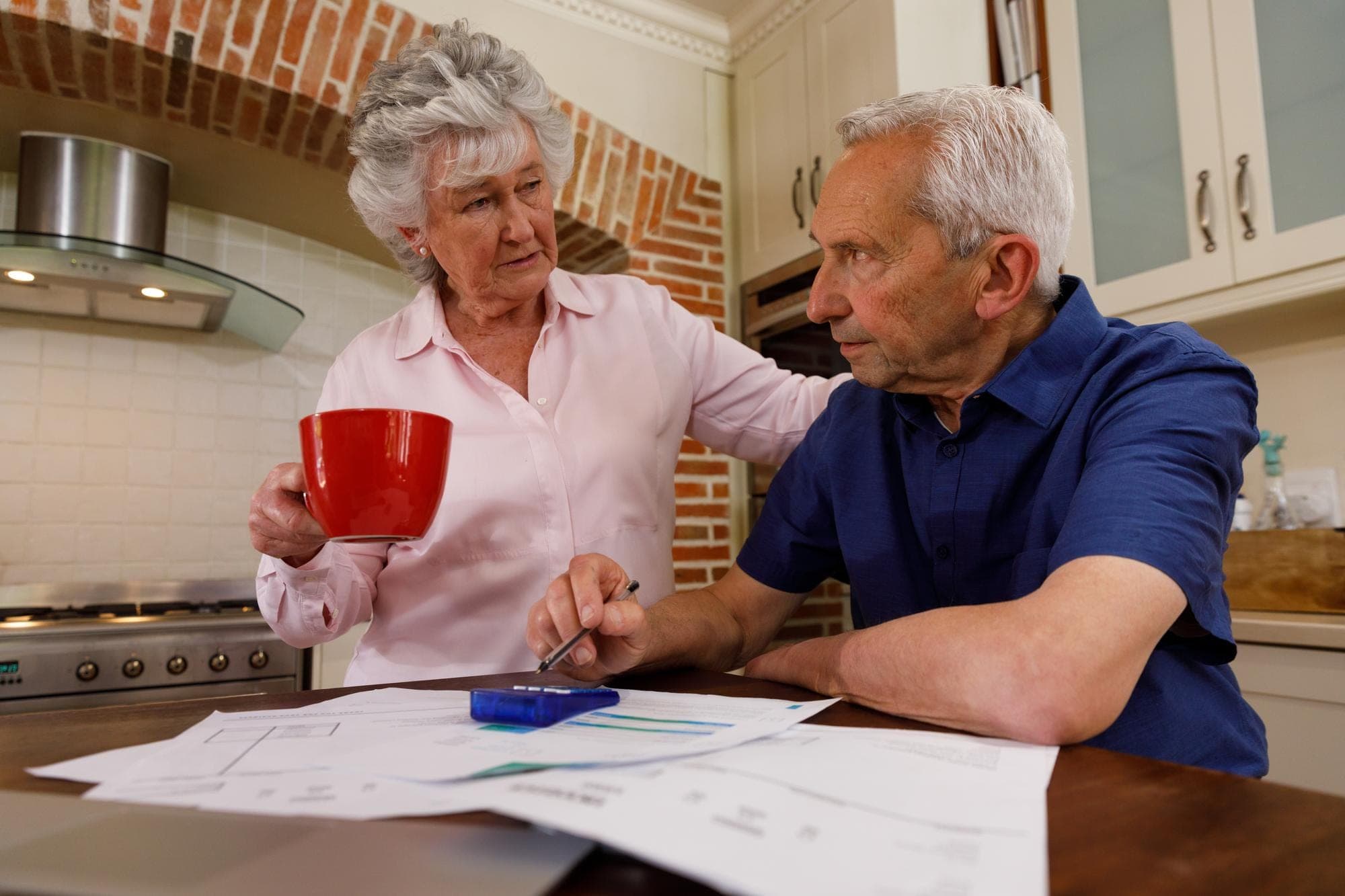 Elderly couple discussing SMSF and capital gains tax planning.