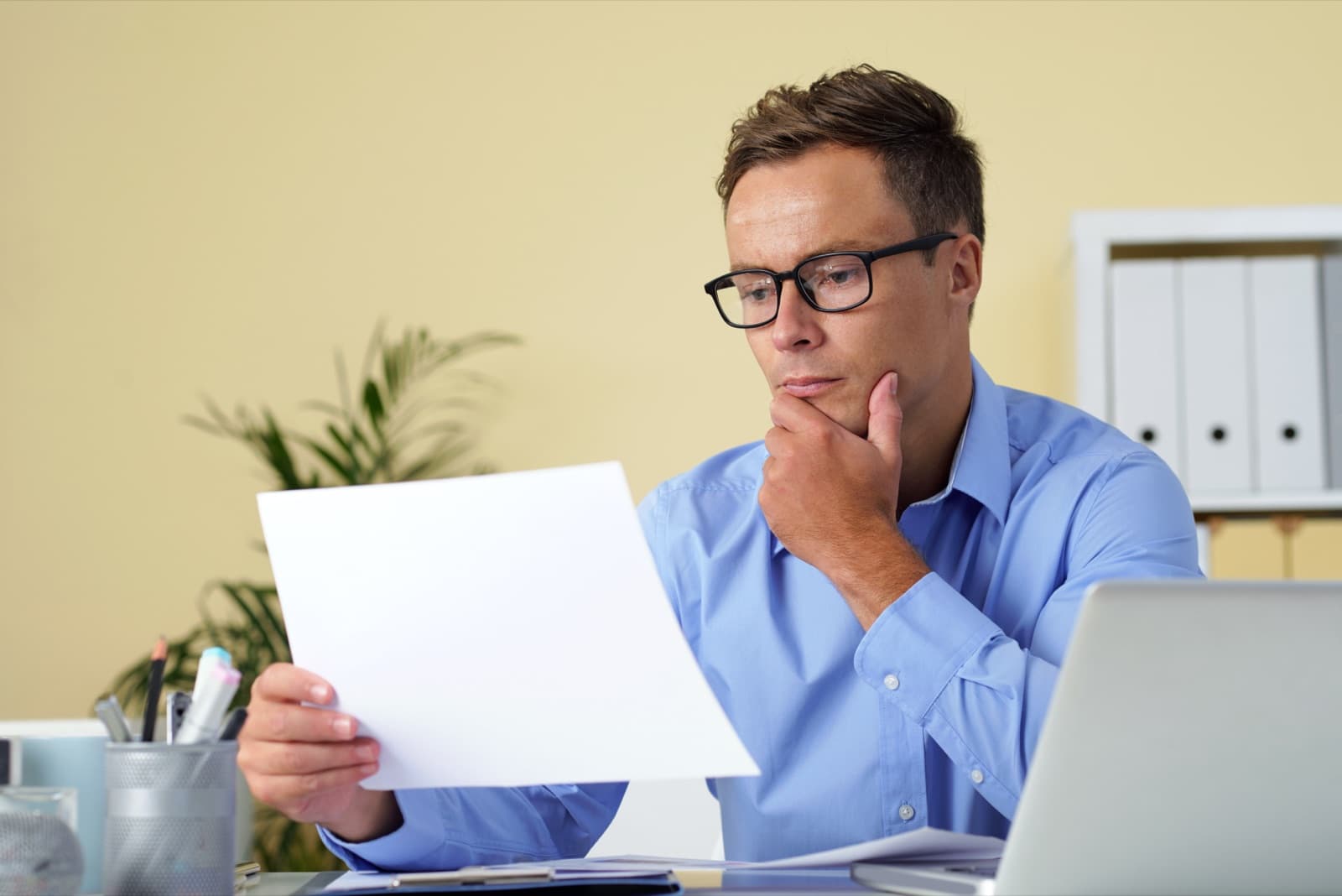 A person comparing two documents side by side at a desk