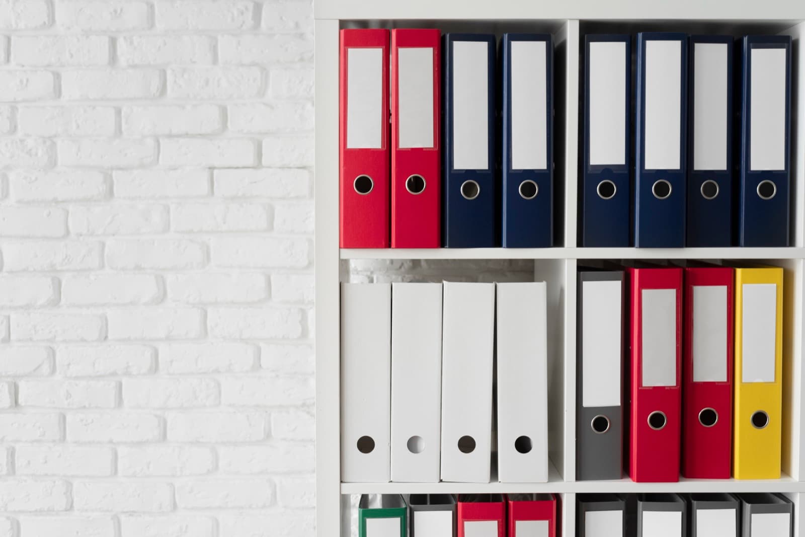 Lever-arch folders organised on an office shelf