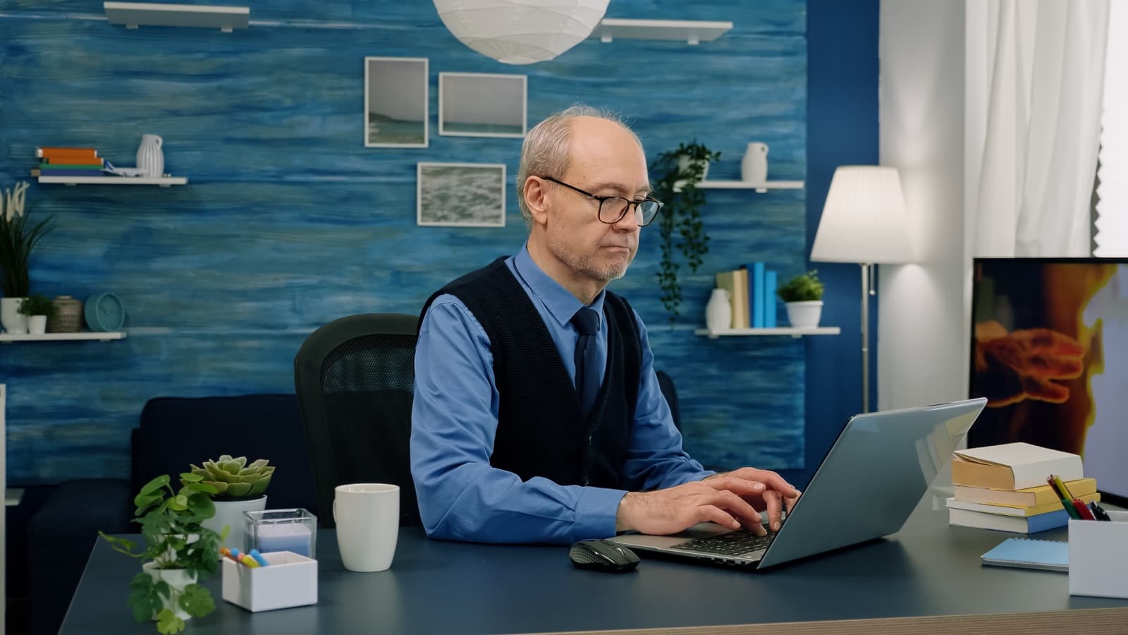 A mature professional working at a laptop