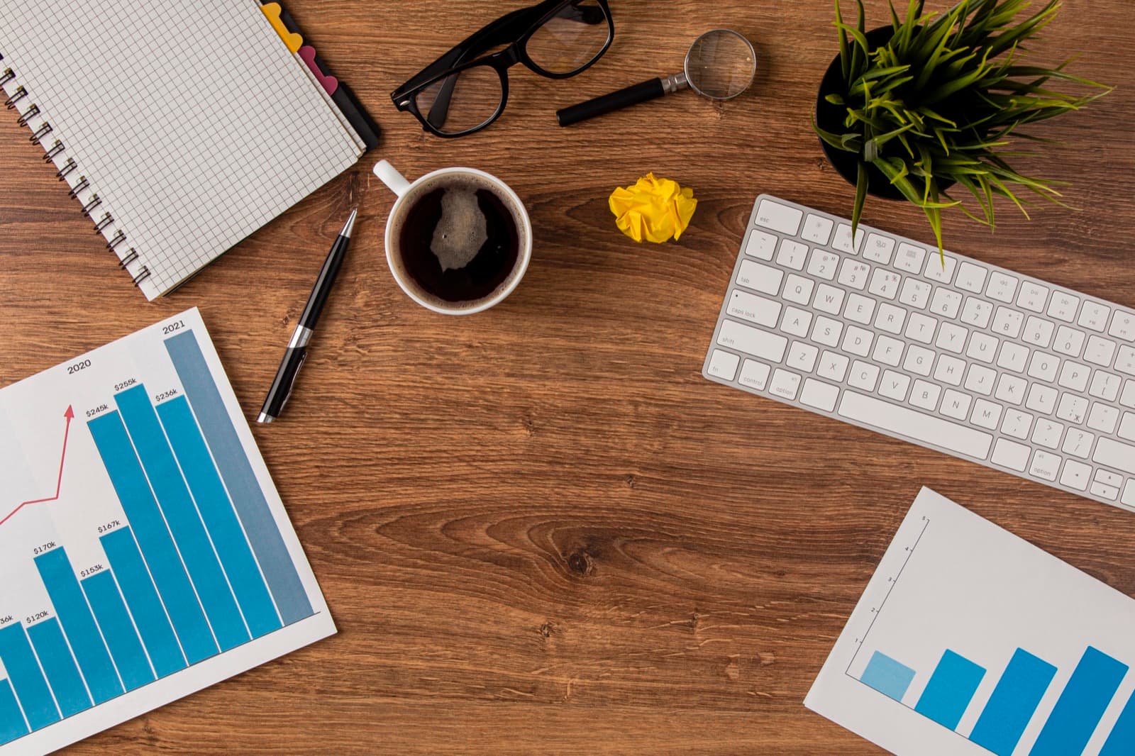 A desk with investment charts and a keyboard