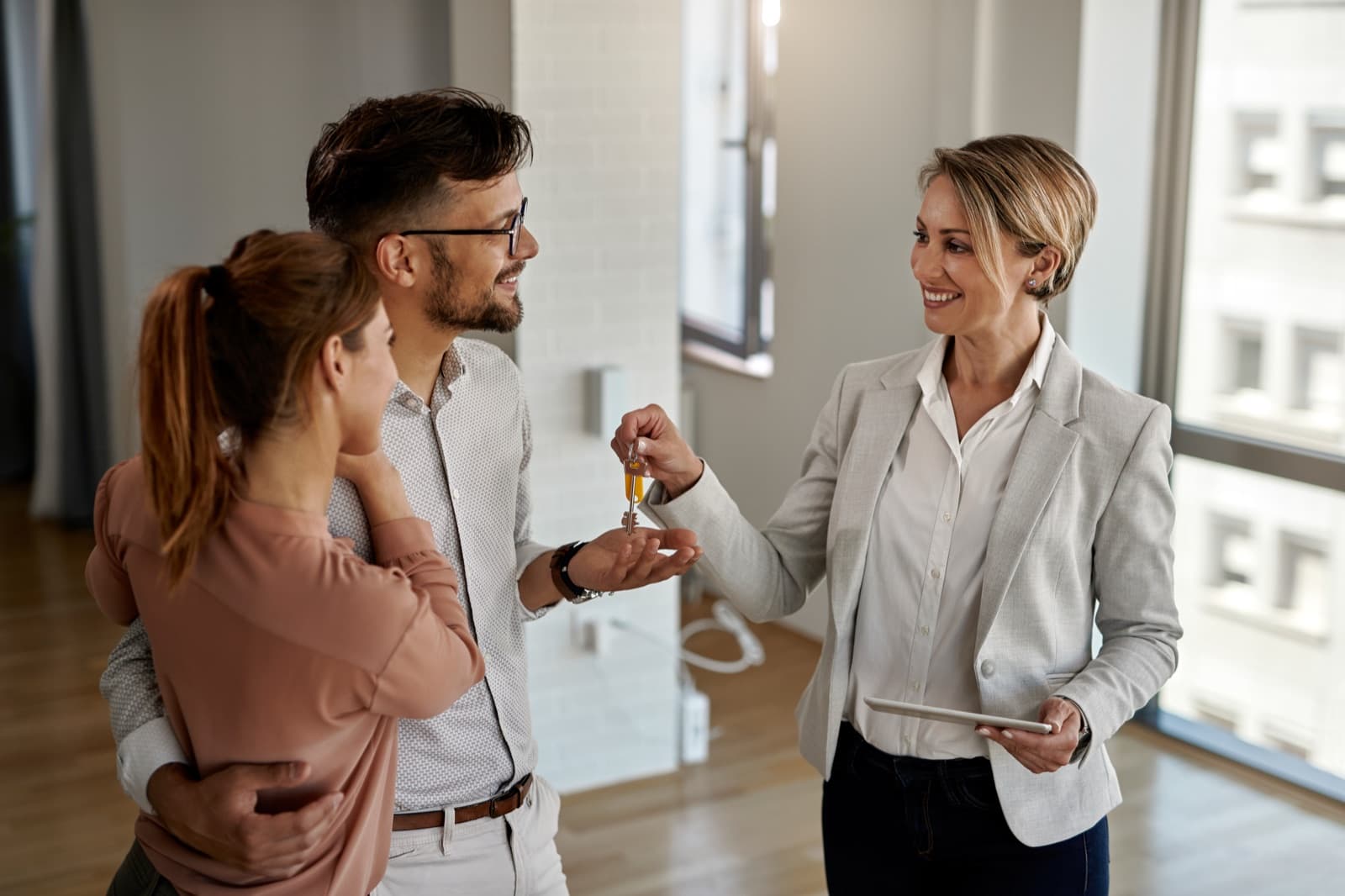 An agent handing keys to a happy couple