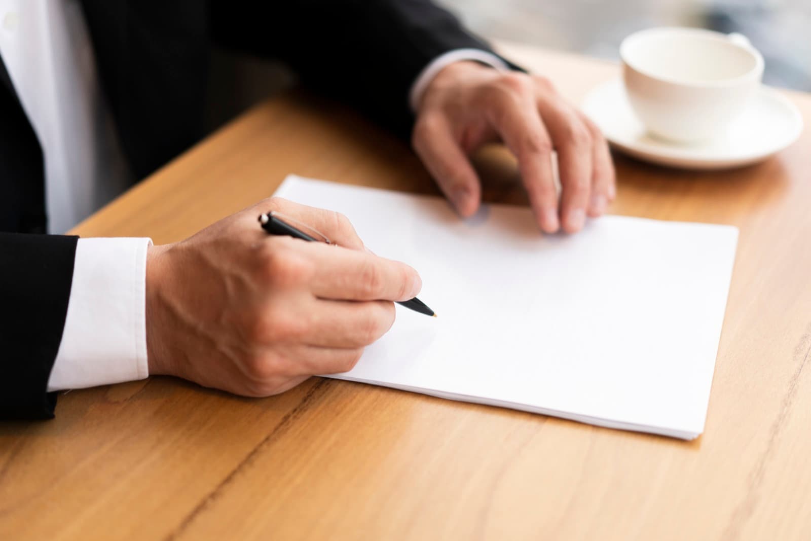 A hand signing an official document with a pen