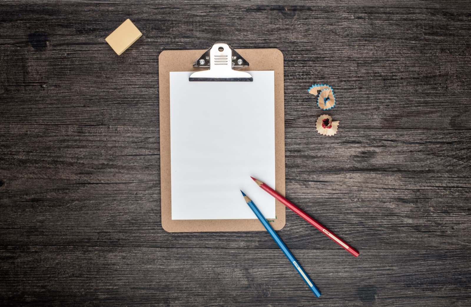 A clipboard and pens on a desk