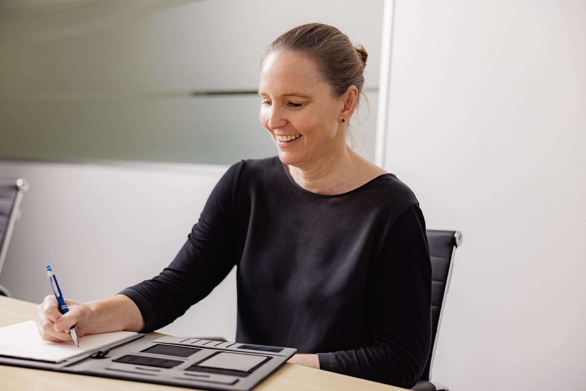 Australian person reviewing financial paperwork calmly at a quiet kitchen table in soft daylight