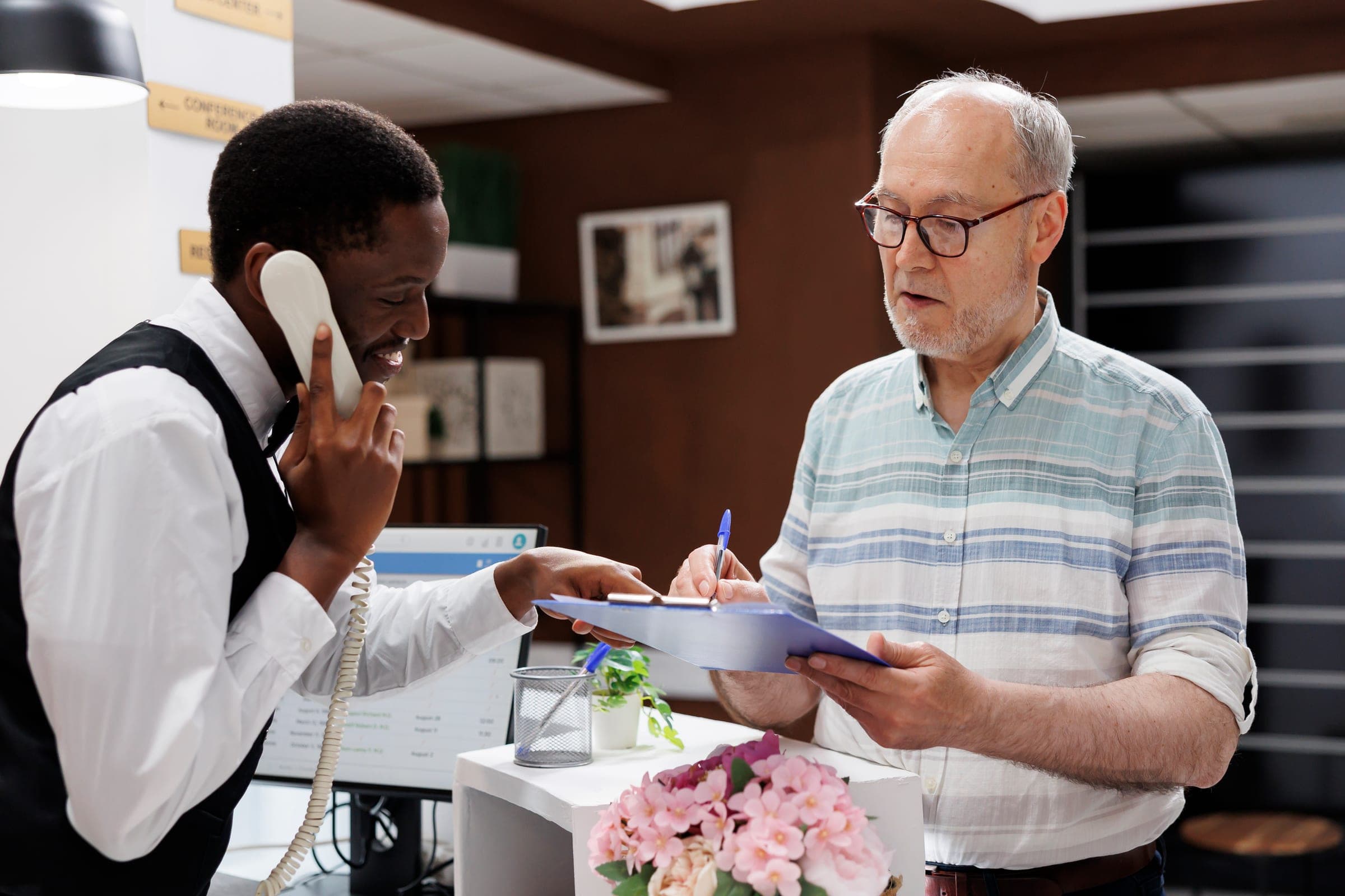 Elderly man signing SMSF death benefit documents in an office.