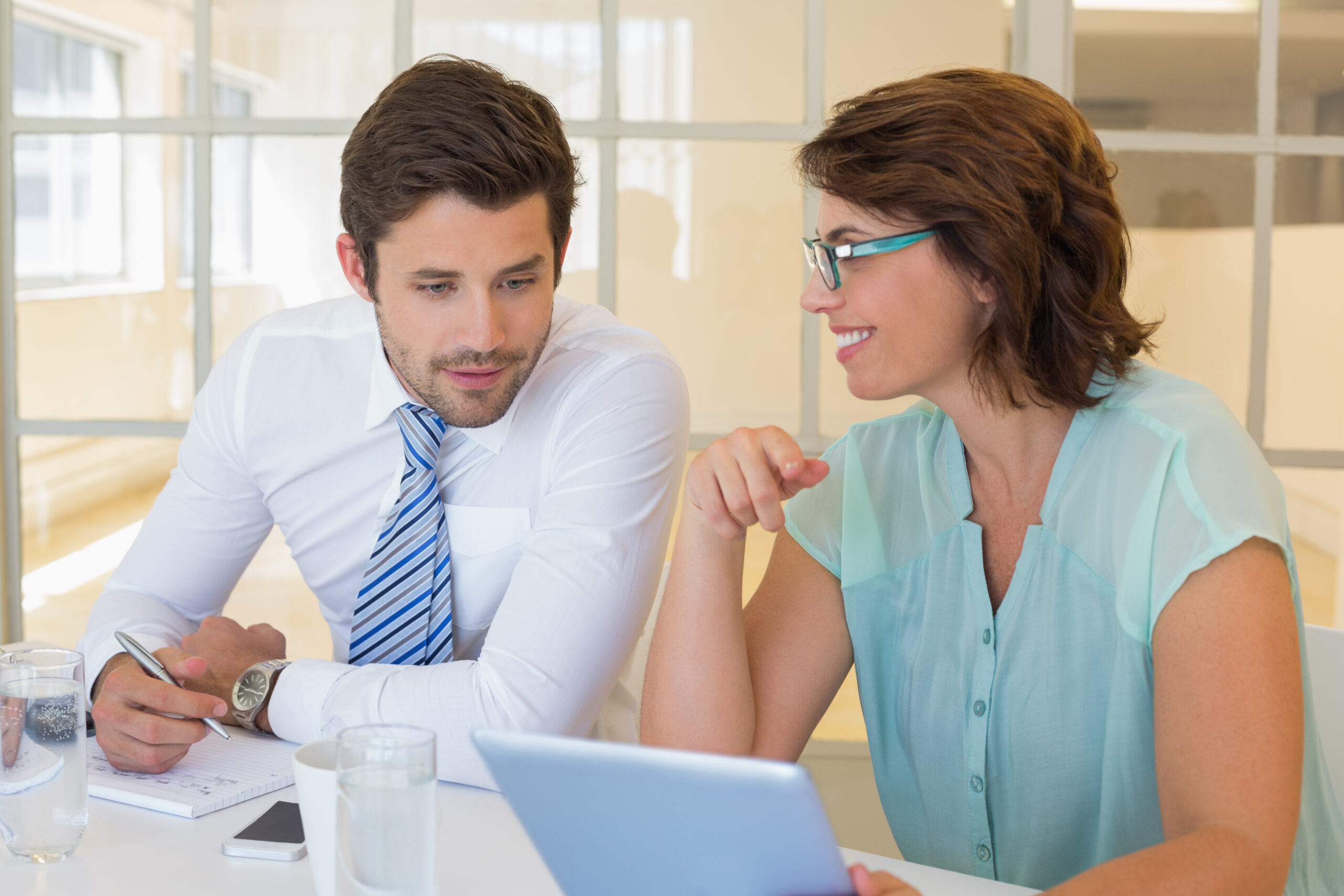 Two professionals discussing financial planning in an office setting.